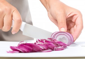 Cook is chopping onion, closeup shoot, isolated over white